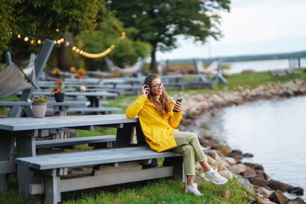 woman on bench listening to podcast